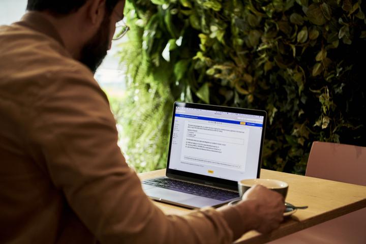 man in brown jacket looking at contract on DocuSign on a laptop