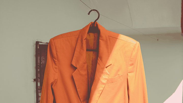 Orange blazer on a hanger in Anchor Group colors