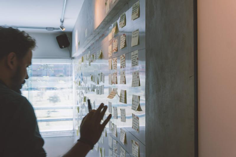 NetSuite Demand Planning male putting sticky notes on wall