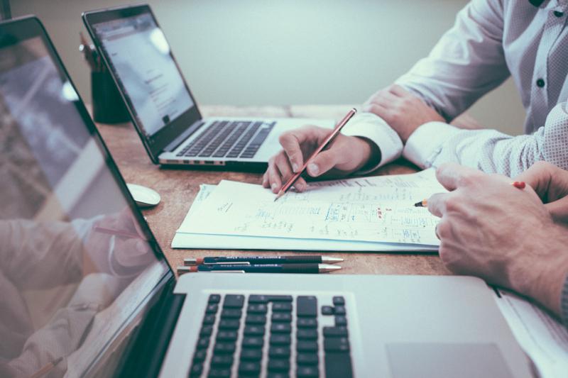 NetSuite Order Management - person holding pencil near laptop computer