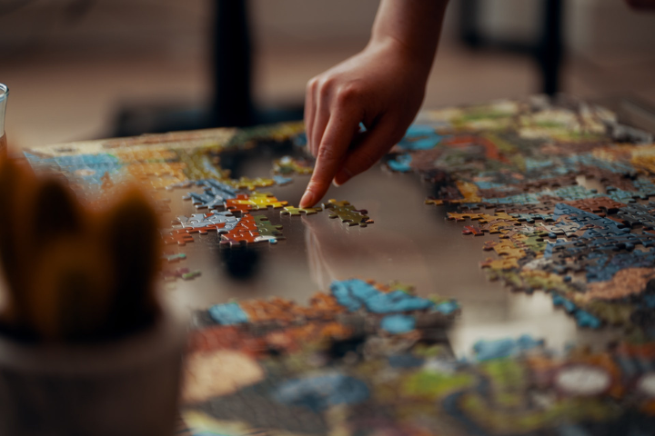 Person holding jigsaw puzzle pieces