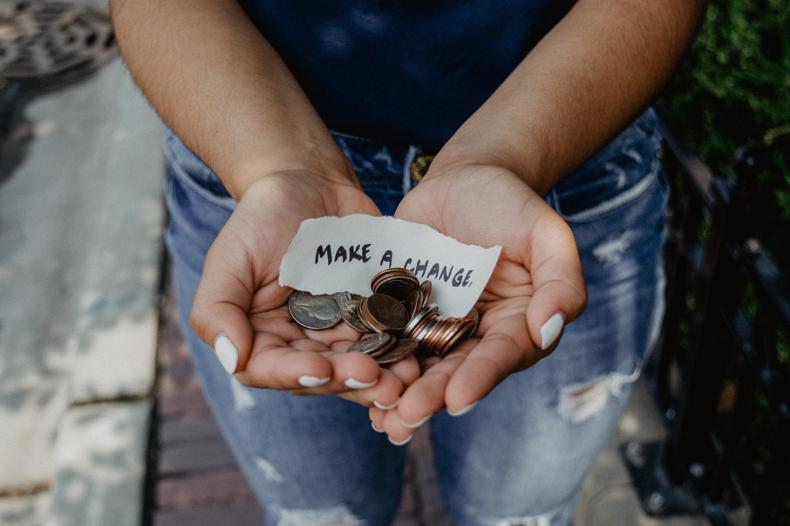 NetSuite for Nonprofit Organizations person showing both hands with make a change note and coins