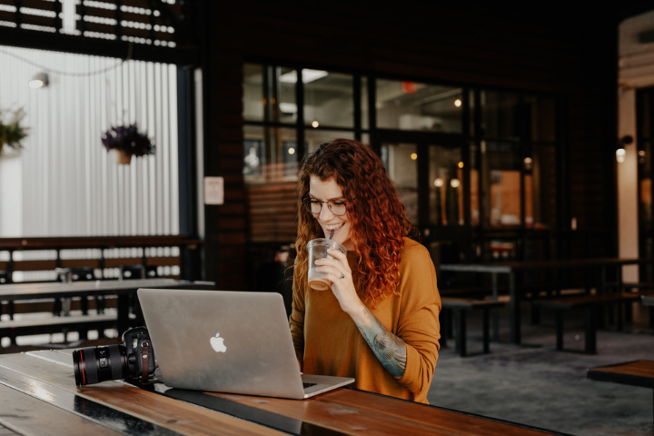 woman in orange long sleeve shirt sitting in front of silver macbook blog