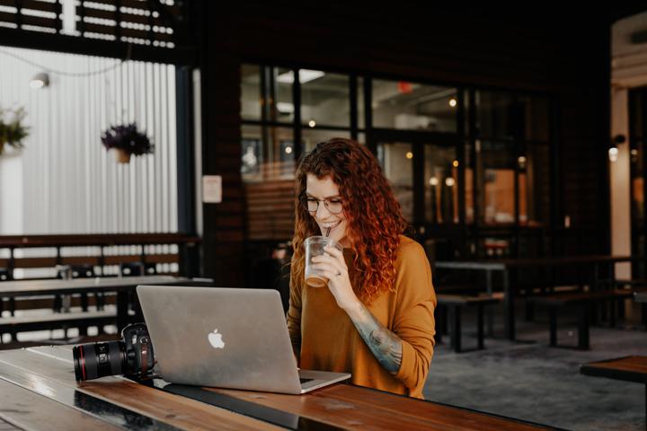 woman in orange long sleeve shirt sitting in front of silver macbook blog