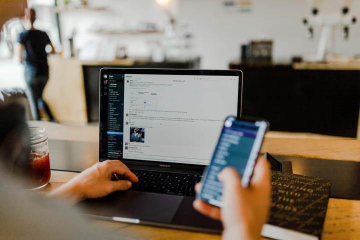 Cell phone while working on laptop with Slack open