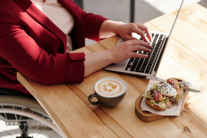 person eating and working on laptop