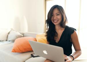 woman in black long sleeve shirt sitting on bed using macbook