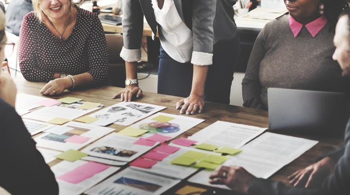 Photo of a team planning around documents on a table