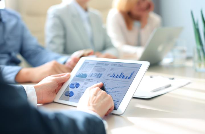 person holding a tablet looking at reports