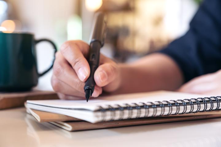 Photo of person writing plans in a notebook