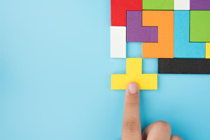 Photo of hand completing puzzle