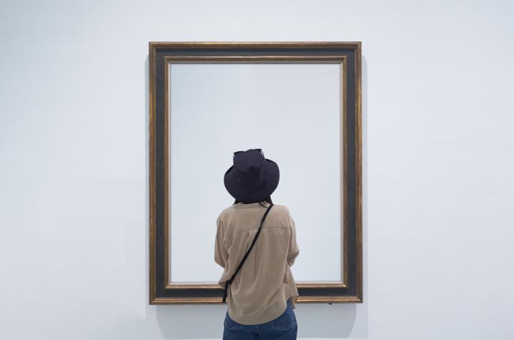 Photo of woman looking at empty visual on gallery wall