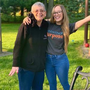 Caregiver smiling with her grandmother in nature