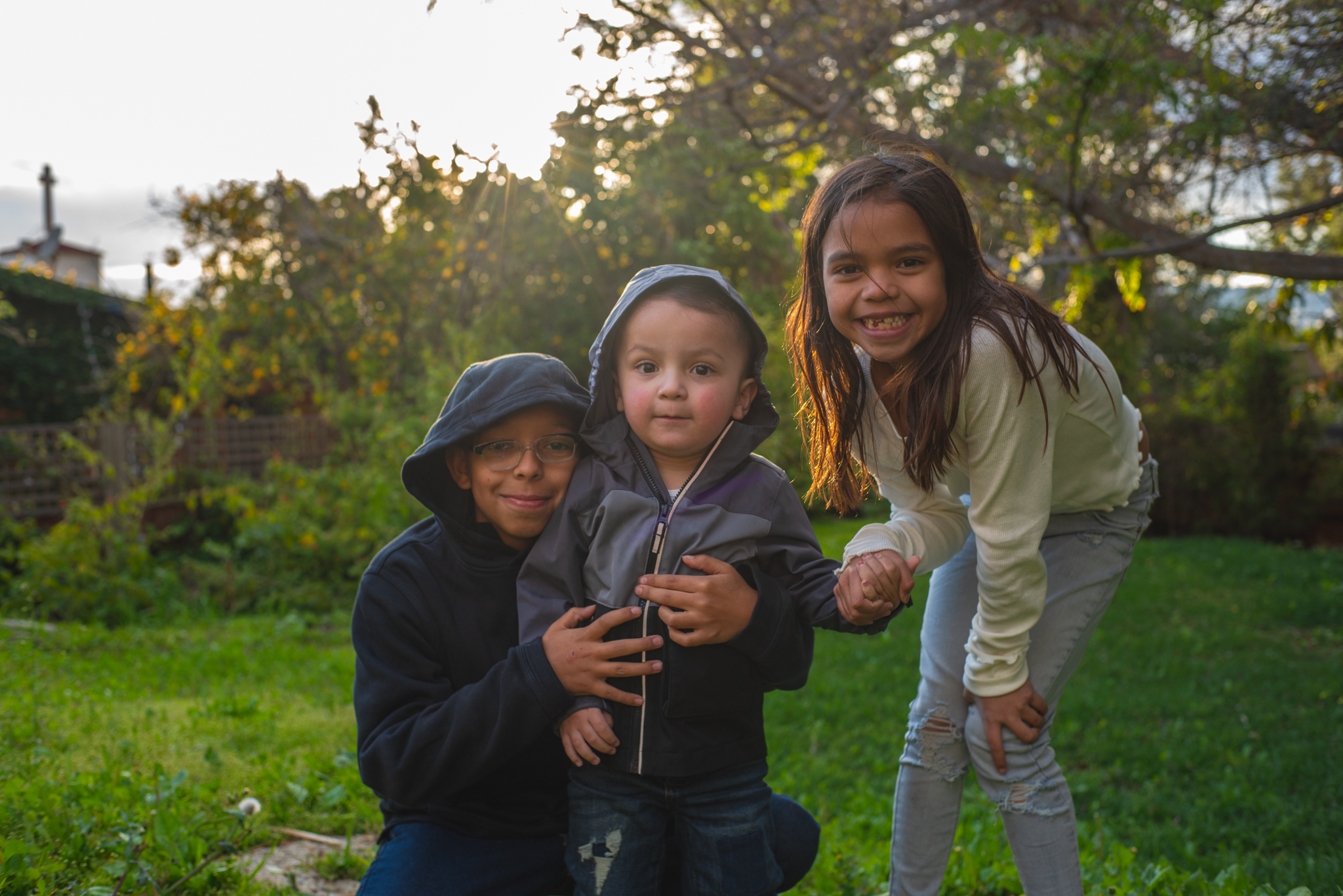 Los Angeles photographer Michael de la Guerra's photo of three children smiling in a backyard during sunset.
