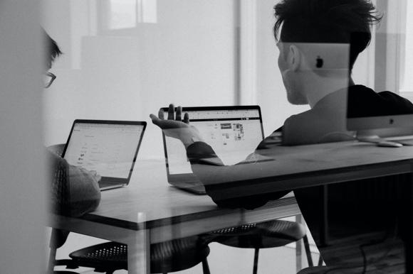 Two people looking at a website copy and design template in an office.