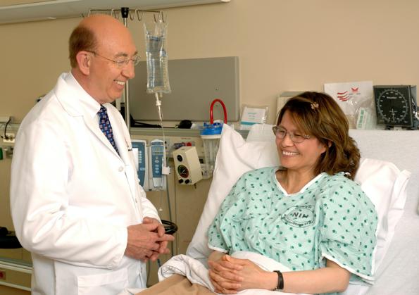 woman in teal scrub suit sitting beside man in white medical scrub suit