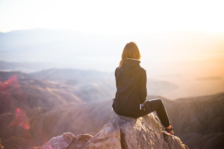 man standing on top of rock mountain during golden hour