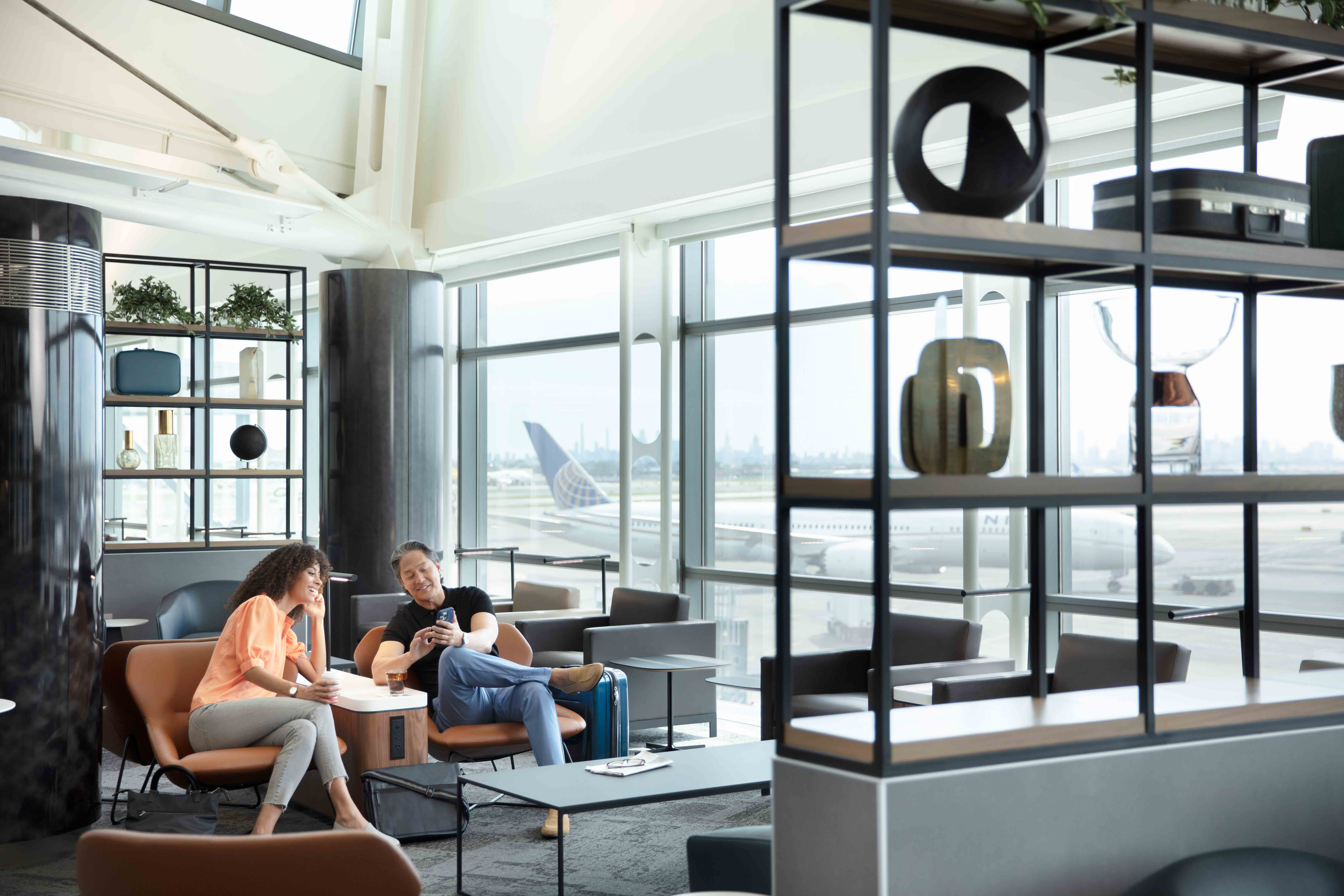 Two travelers sitting in the United Club