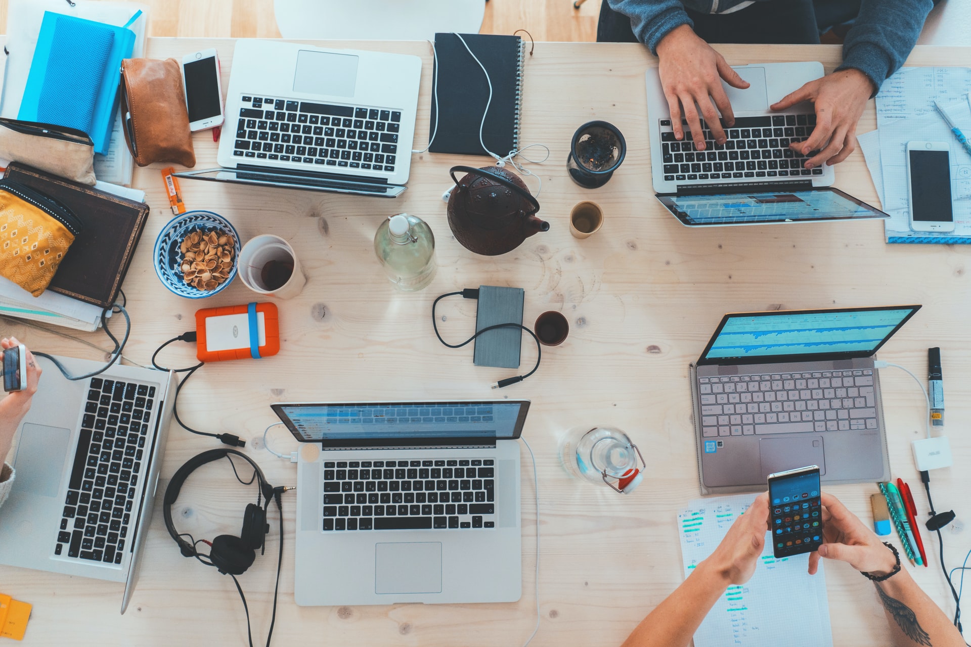 people sitting down near table with assorted laptop computers - technology keeps us intelligent if used wisely