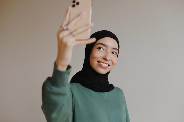woman in green long sleeved shirt holding iphone 6